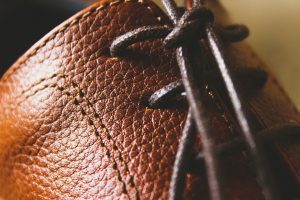 A section of a brown textured leather boot, with laces